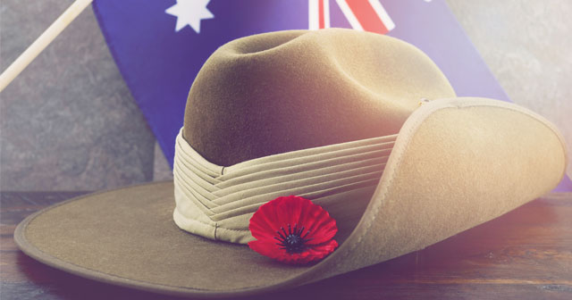 Sloach hat with a poppy on placed next to a hanging Australian flag.