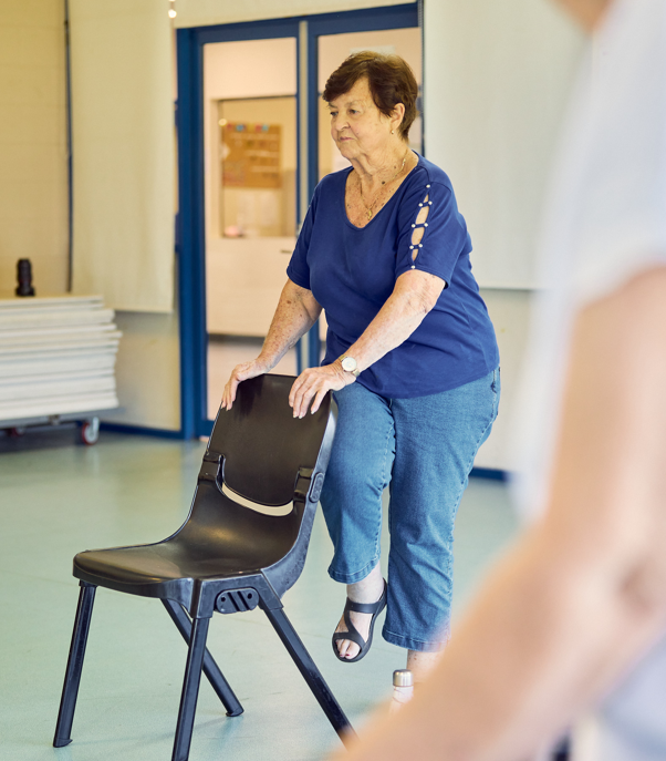 A woman doing pilates using a chair