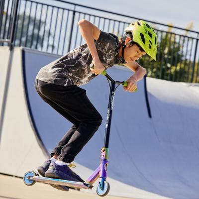 A boy on a scooter in a skate park.