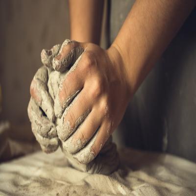 A person crafting clay with their hands