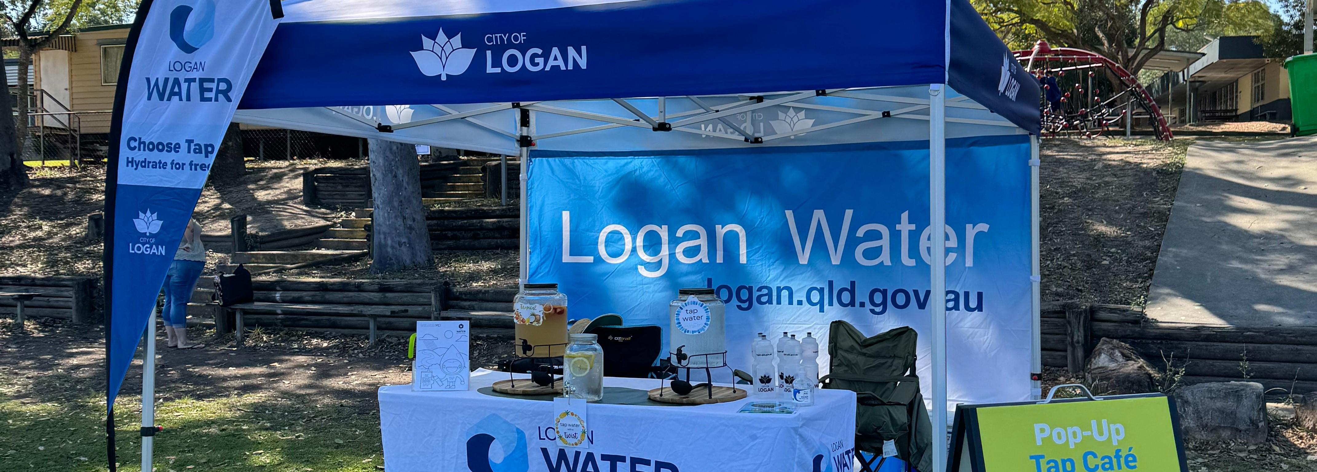 A tent at an event with urns of water with fruit for customers to drink