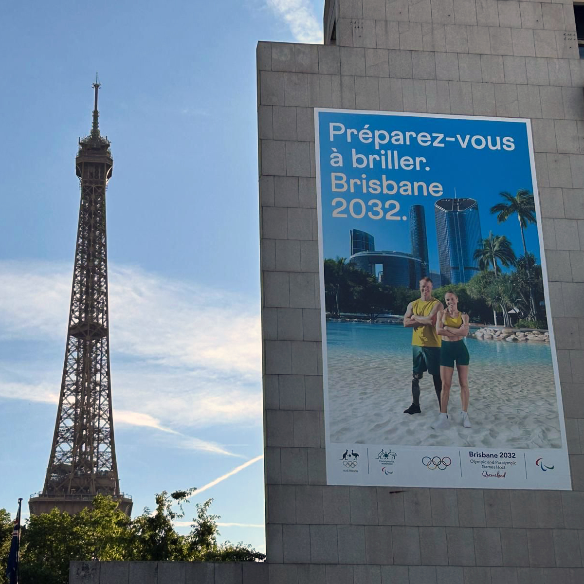 An image of the Brisbane 2032 billboard in Paris that features Logan athlete Genevieve Gregson. The Eiffel Tower is in the background.