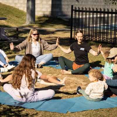 Group of children sit in a circle and perform yoga moves