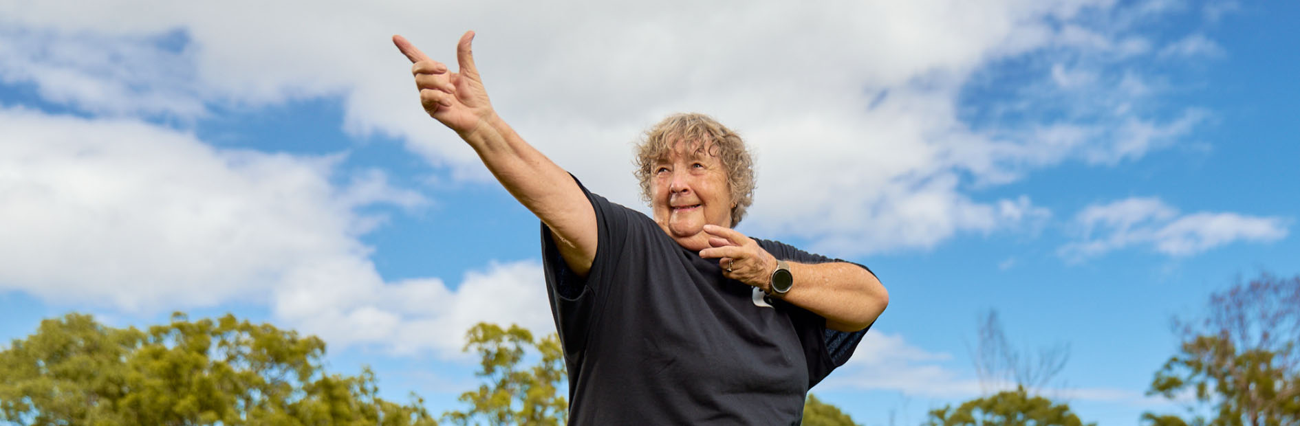 Elderly woman dressed in black does yoga moves