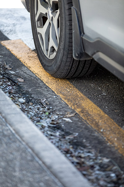 A yellow line on a road indicating where there is no parking