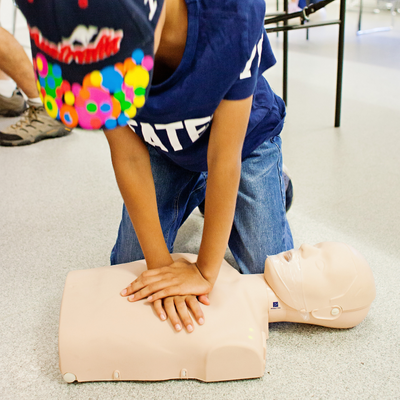 Child performs CPR on a dummy