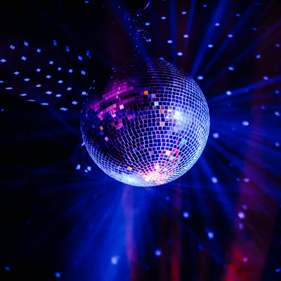 A glittery disco ball shining with blue and pink lights