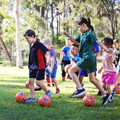 a group of children playing with footballs
