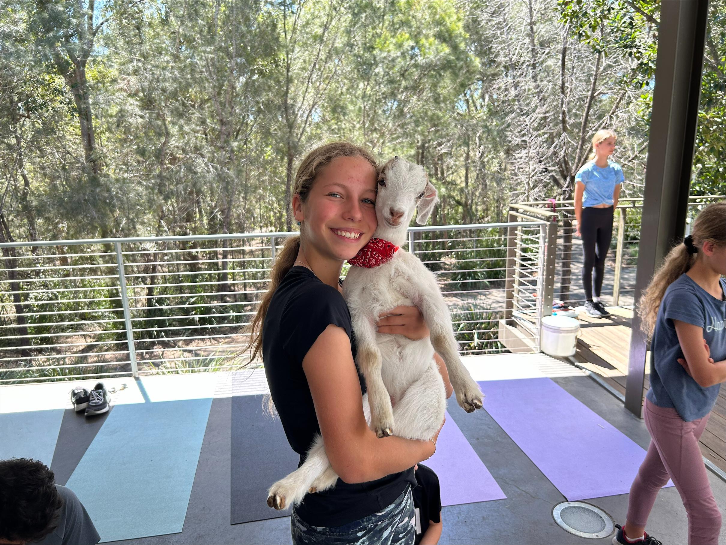 A girl cuddling a baby goat