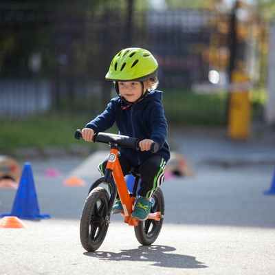 Young boy riding a bike with a helmet on