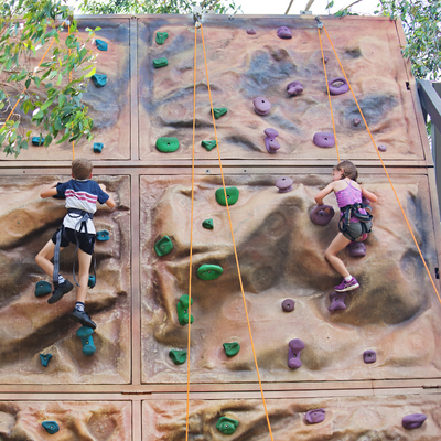 Young people climbing a rock climbing wall