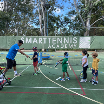 Young children with instructor learning tennis