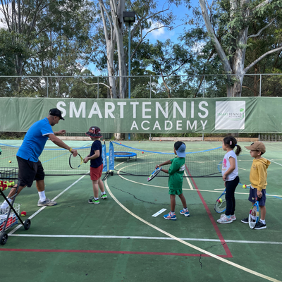 Children playing tennis on a tennis court