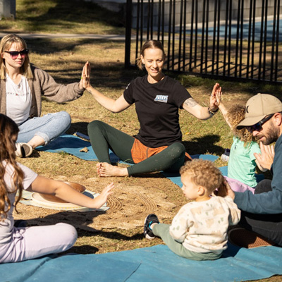 Children and adults sitting in a circle doing yoga poses